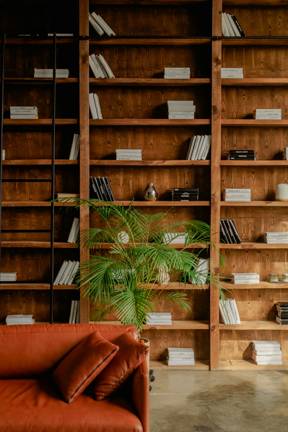 Snug with a sofa and floor-to-ceiling bookshelves used as a room divider