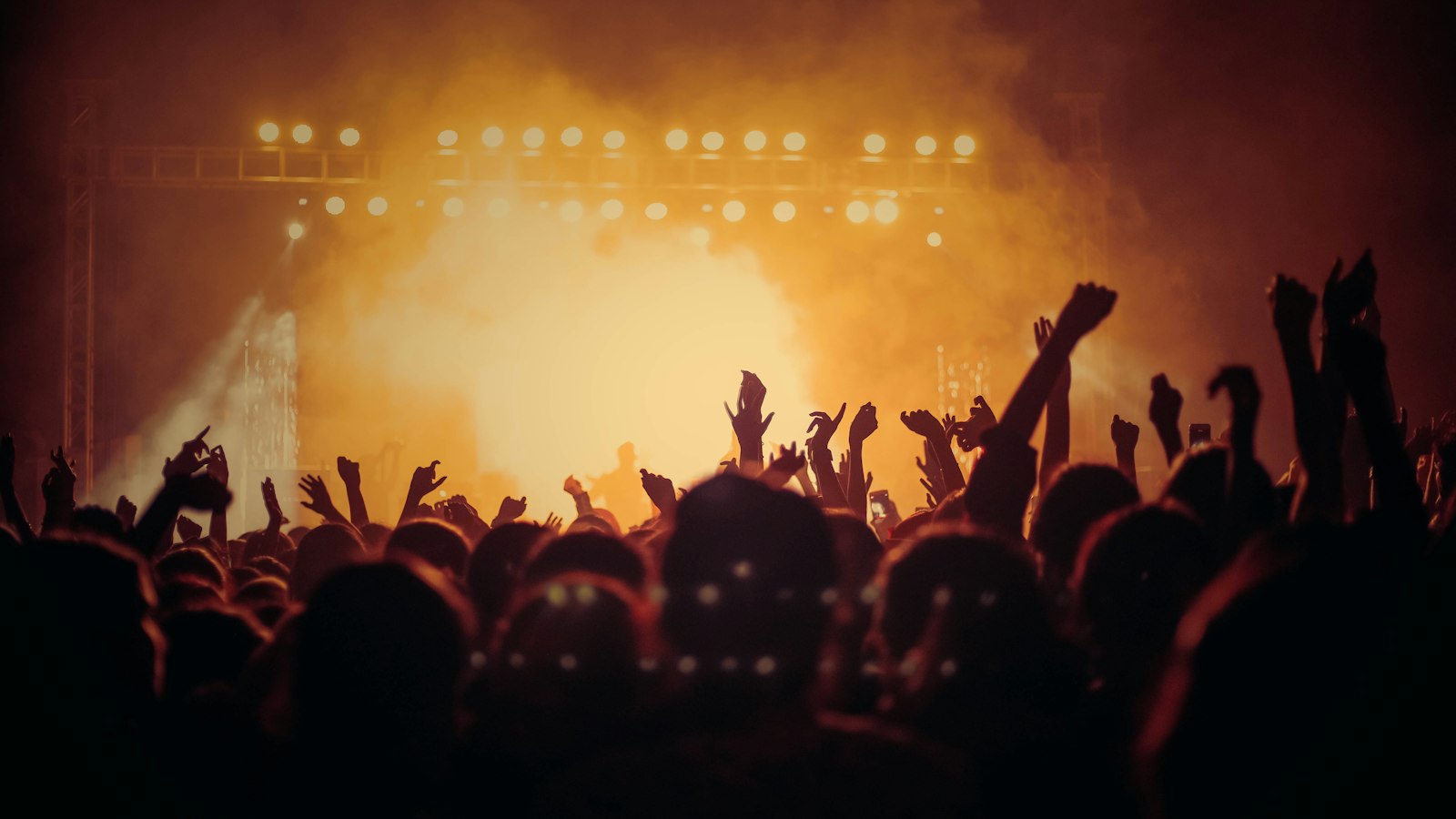 Band performing on an arena stage in front of a crowd