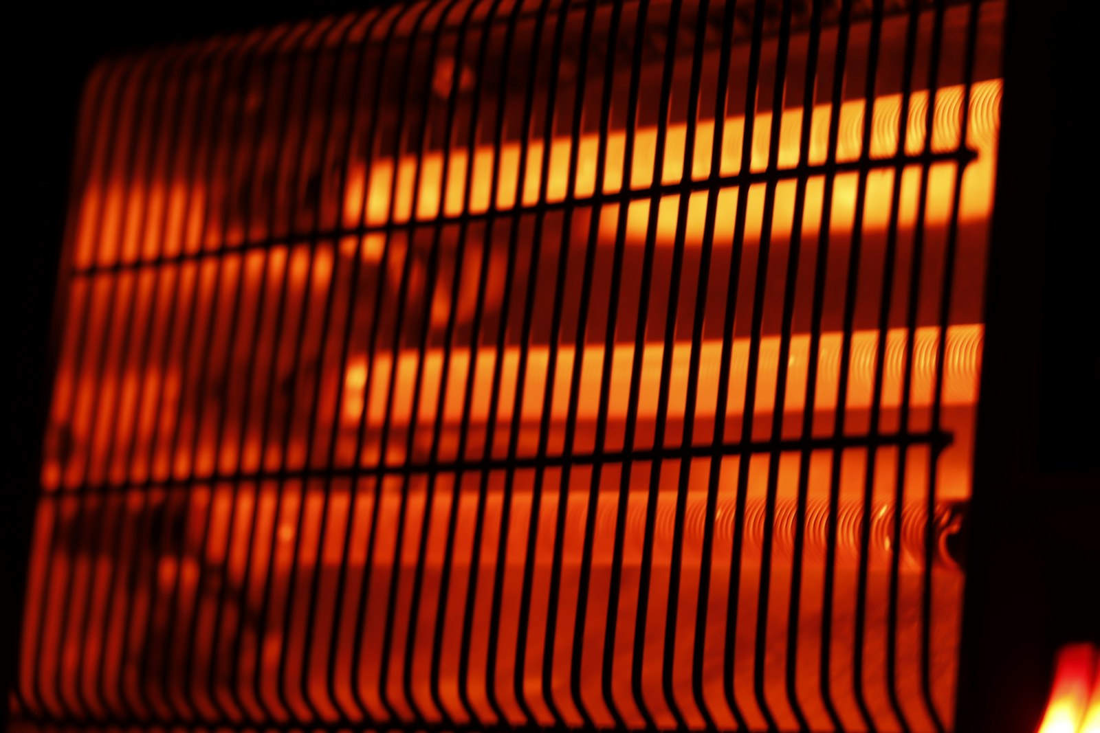 The glowing bars of a halogen heater, which warms the person in front of it rather than the air in the room