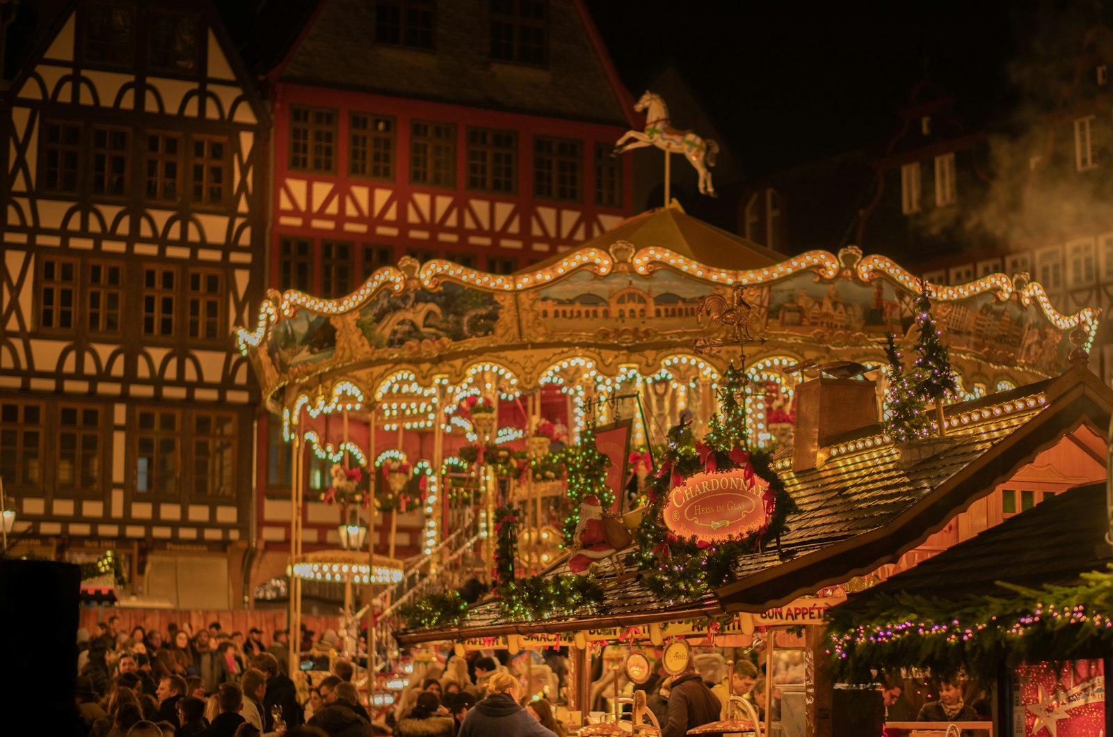 Carousel and half-timbered houses at a German Christmas market at night
