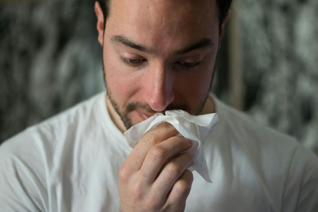 A man blowing his nose into a tissue - the start of Britain's cold and flu season and the search for cold and flu remedies that actually work