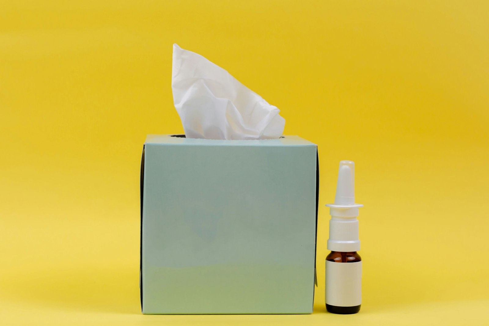 A decongestant nasal spray next to a box of tissues - the spray form works, unlike the phenylephrine tablets in most cold and flu sachets