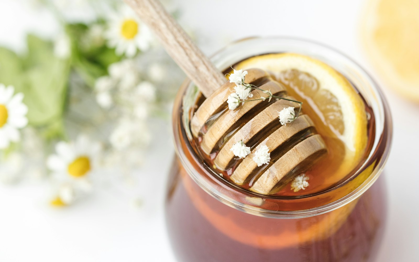 A jar of honey with a wooden dipper - one of the few cold and flu remedies that actually work for a cough, according to NICE and an Oxford meta-analysis
