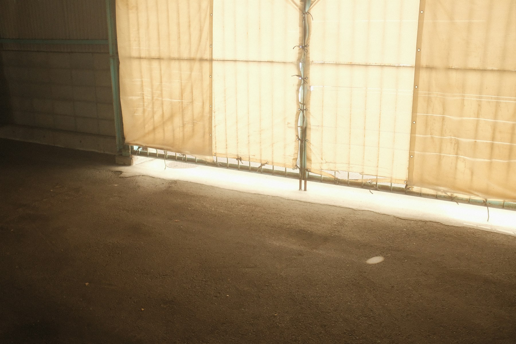 Floor-to-ceiling beige curtains in an empty room with a large window