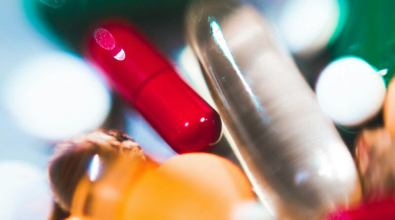 Close-up of red and clear supplement capsules - do probiotics actually work for most people who buy them