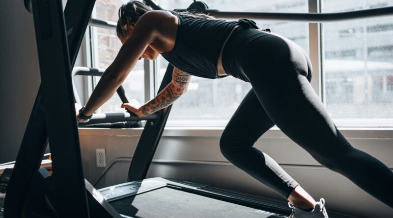 Woman training on a fitness machine, illustrating the question of whether vibration plates work