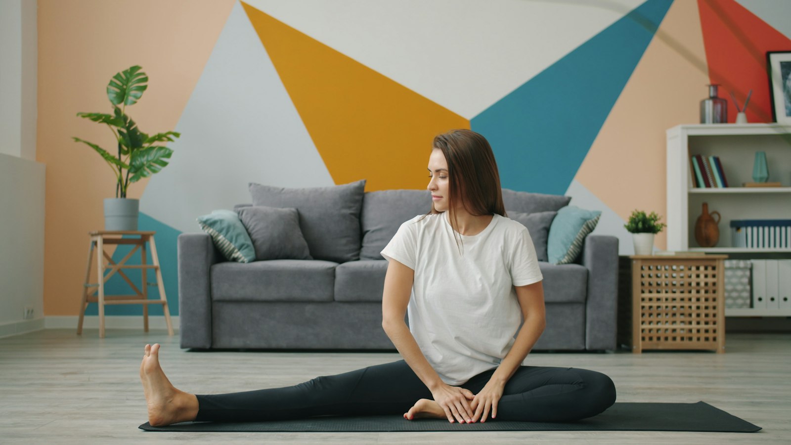 Woman stretching on a mat in a living room, the kind of home setting where people ask whether vibration plates work