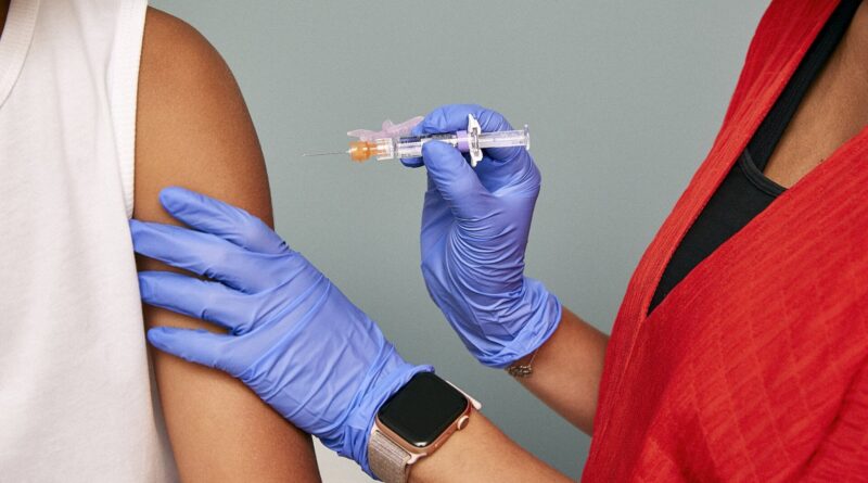 Nurse giving a flu jab 2026 injection into a patient upper arm