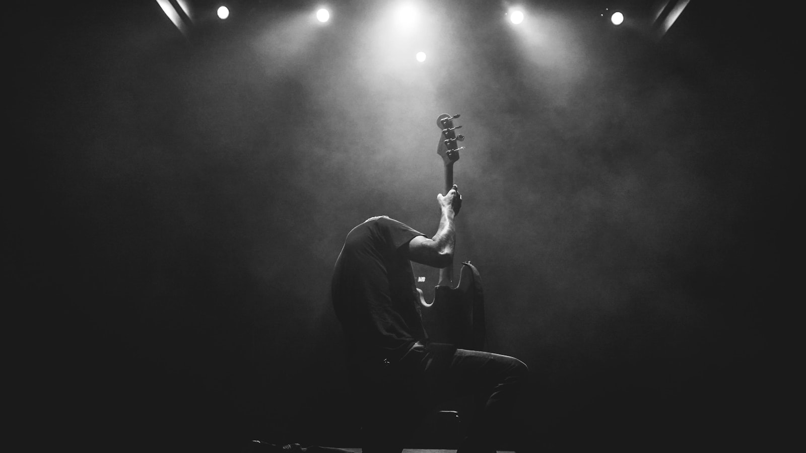 Guitarist under a spotlight on a live stage
