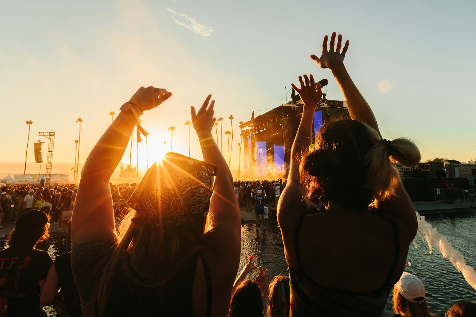 Festival crowd with hands raised in a summer field - demand for Glastonbury 2027 tickets will dwarf supply