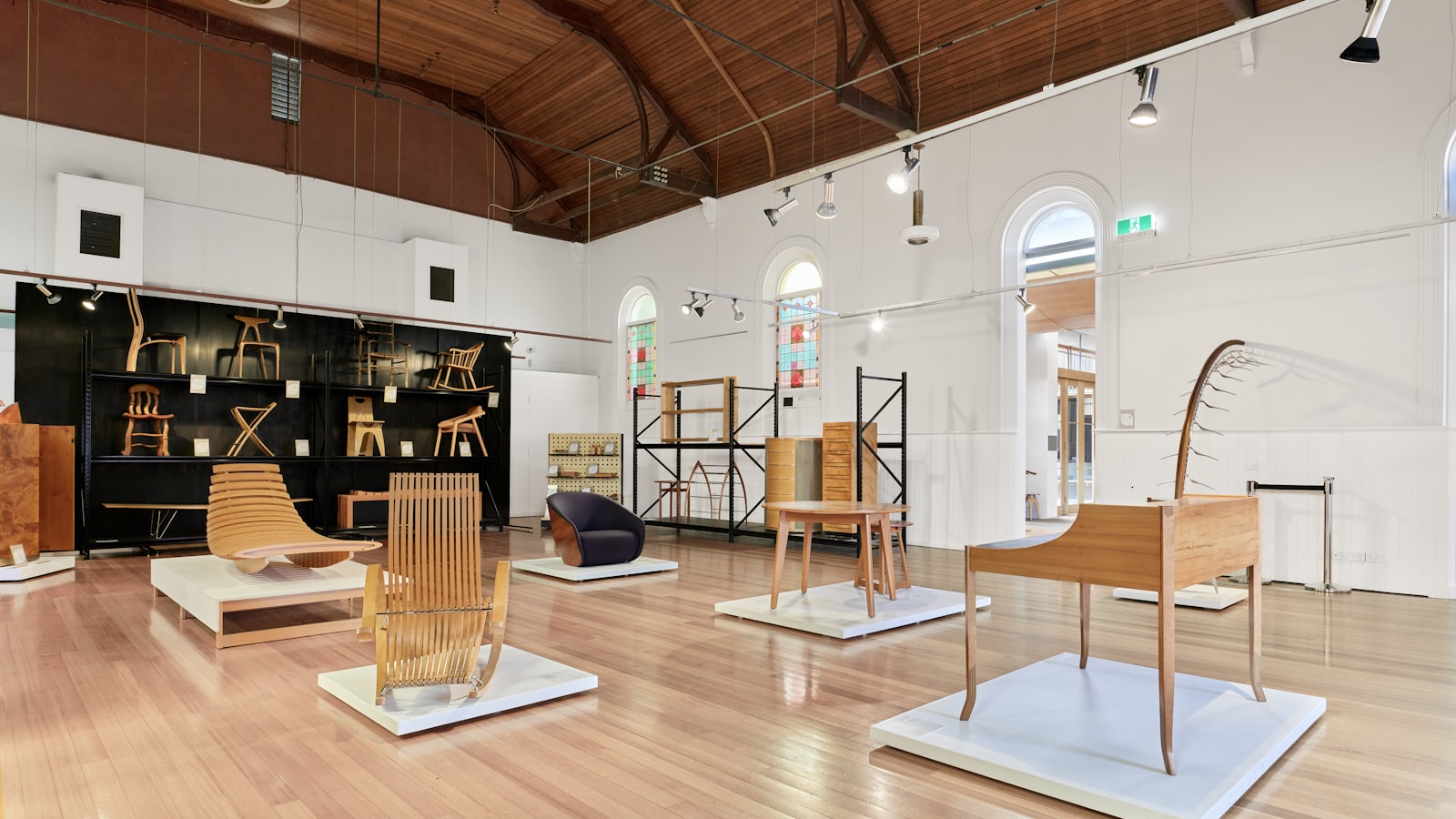 Rows of designer chairs displayed in a bright exhibition hall during a design week