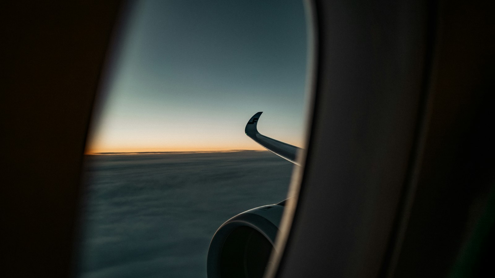 Aeroplane wing at sunset seen through a cabin window - jet lag is where melatonin has its strongest evidence
