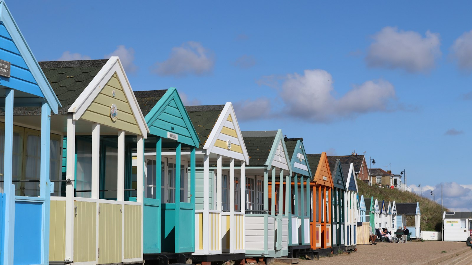 Row of colourful beach huts on a British seafront, the kind of UK coast destination families book for October half term breaks 2026