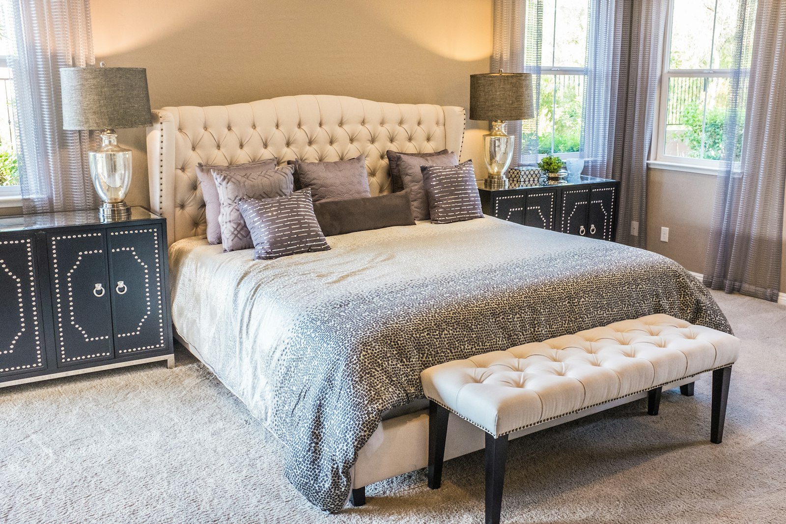 Wide tufted upholstered headboard in a bedroom, an example of oversized headboard ideas for 2026