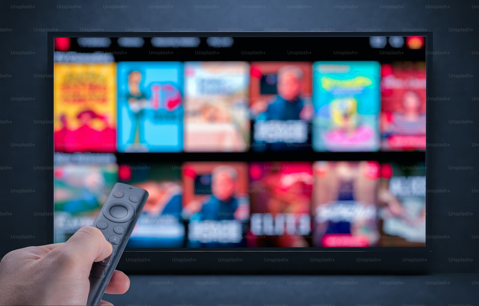Hand pointing a remote at a television - rotating streaming services starts with the cancel button