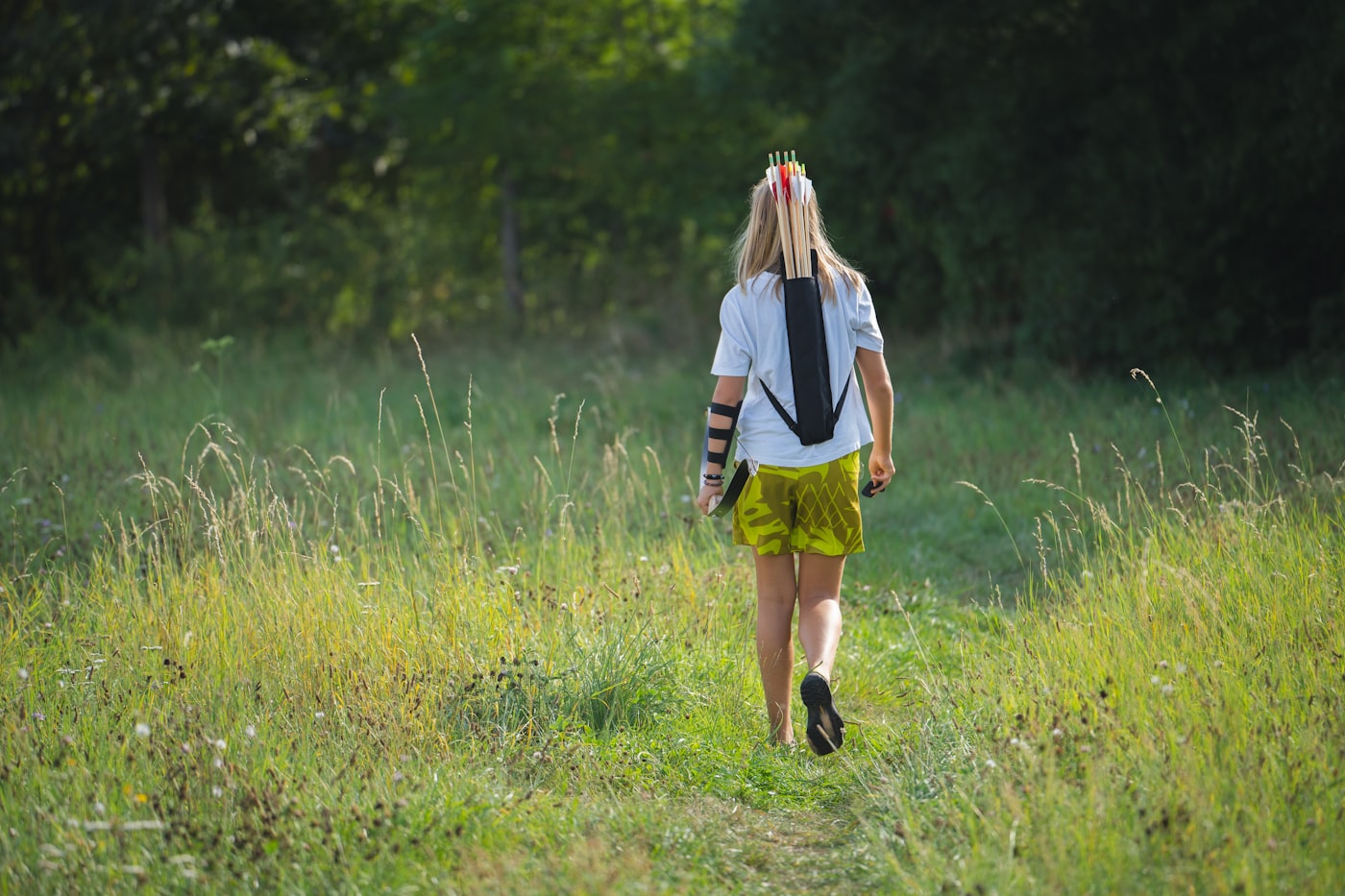 Woman walking through a field with a backpack for a weighted walk