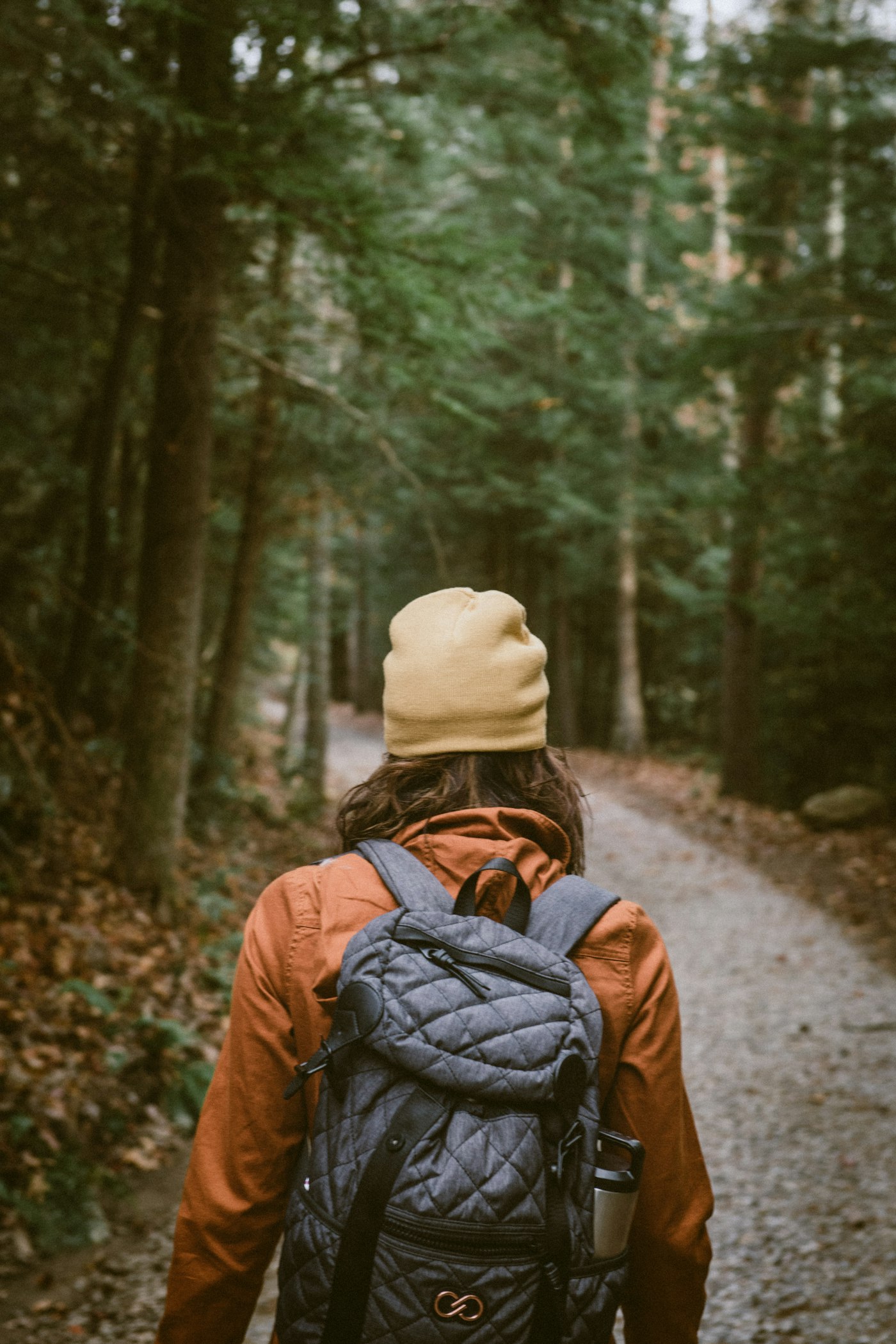 Woman rucking with a loaded backpack on a woodland trail