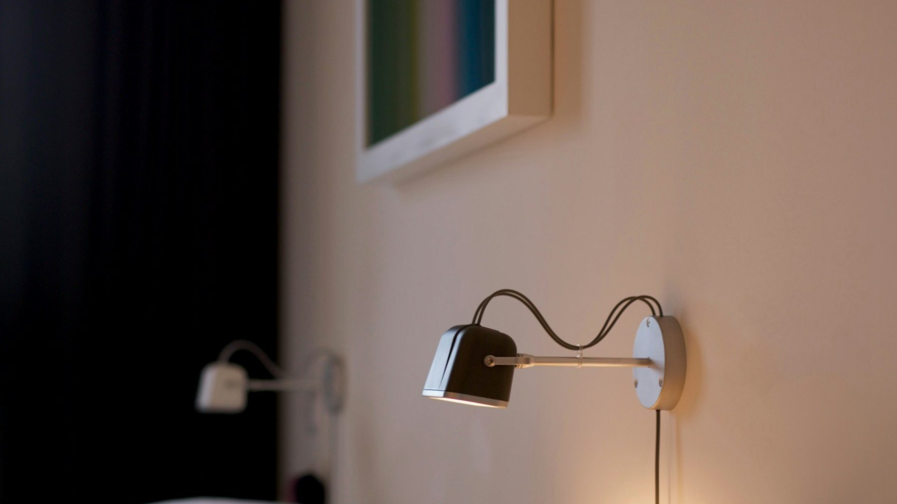 A small wall-mounted lamp glowing softly, the sort of ordinary light that a SAD lamp is not