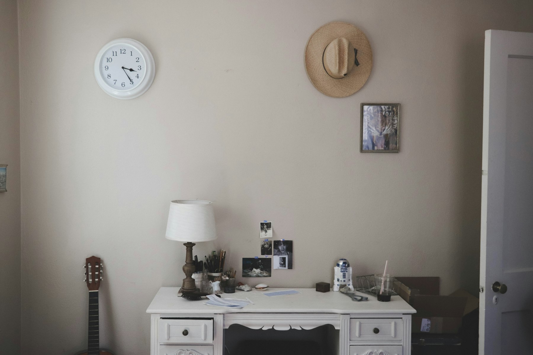 A table lamp on a desk beside a closed door in a dim room, illustrating why ordinary indoor lighting falls short of a SAD lamp