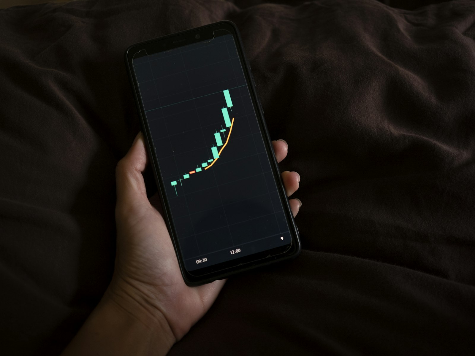 A person checking sleep tracker accuracy data on a phone in bed in the morning