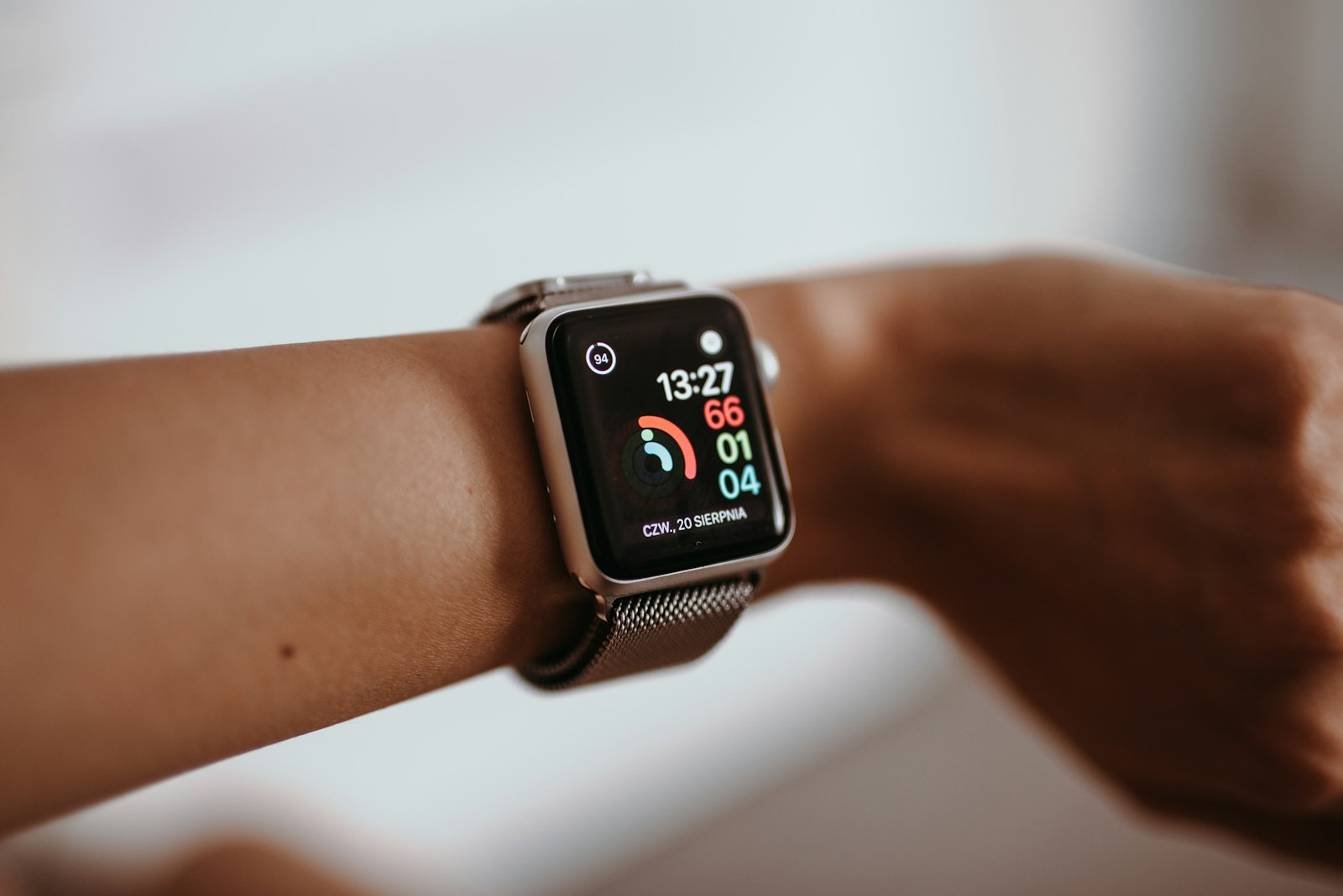 Smartwatch on a wrist beside a bed, one of the sleep trackers tested for accuracy