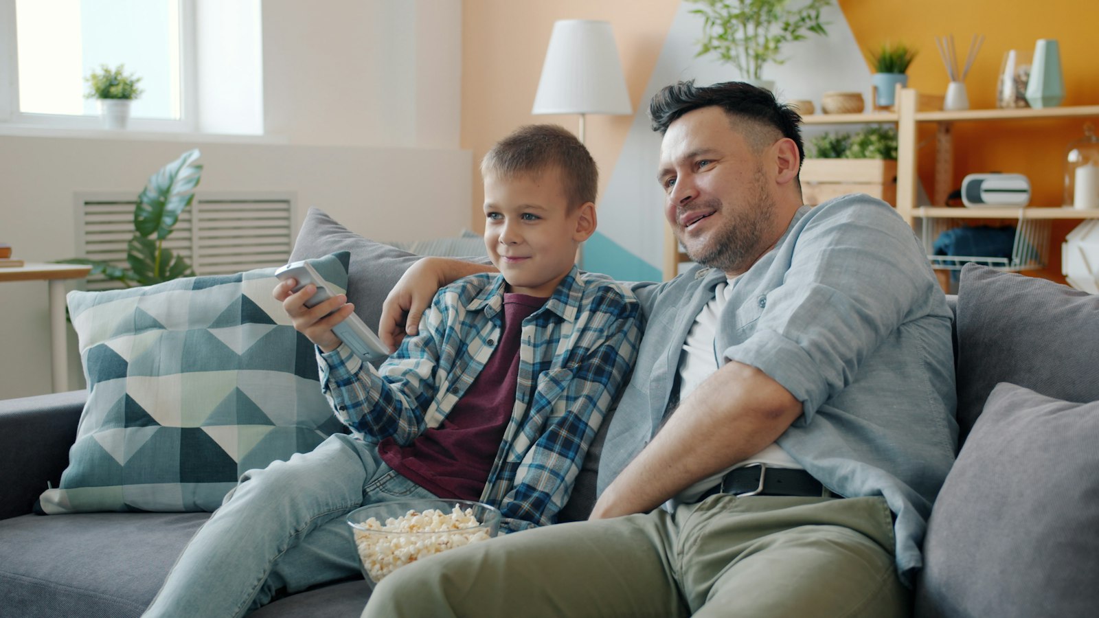 A family watching Saturday night television together on the sofa