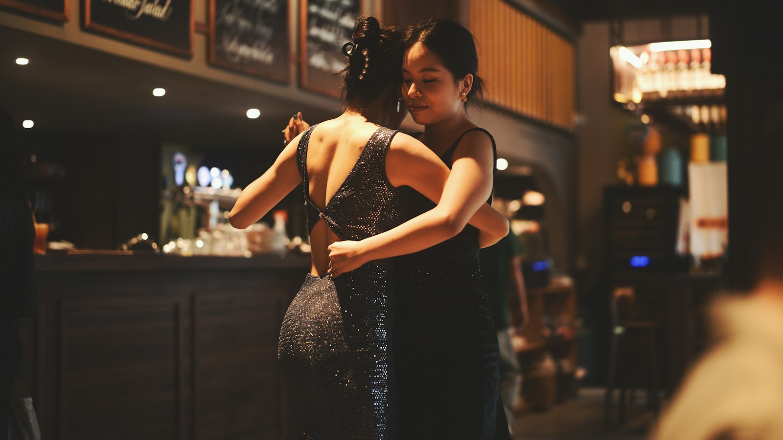 Two women dancing together in a dimly lit ballroom