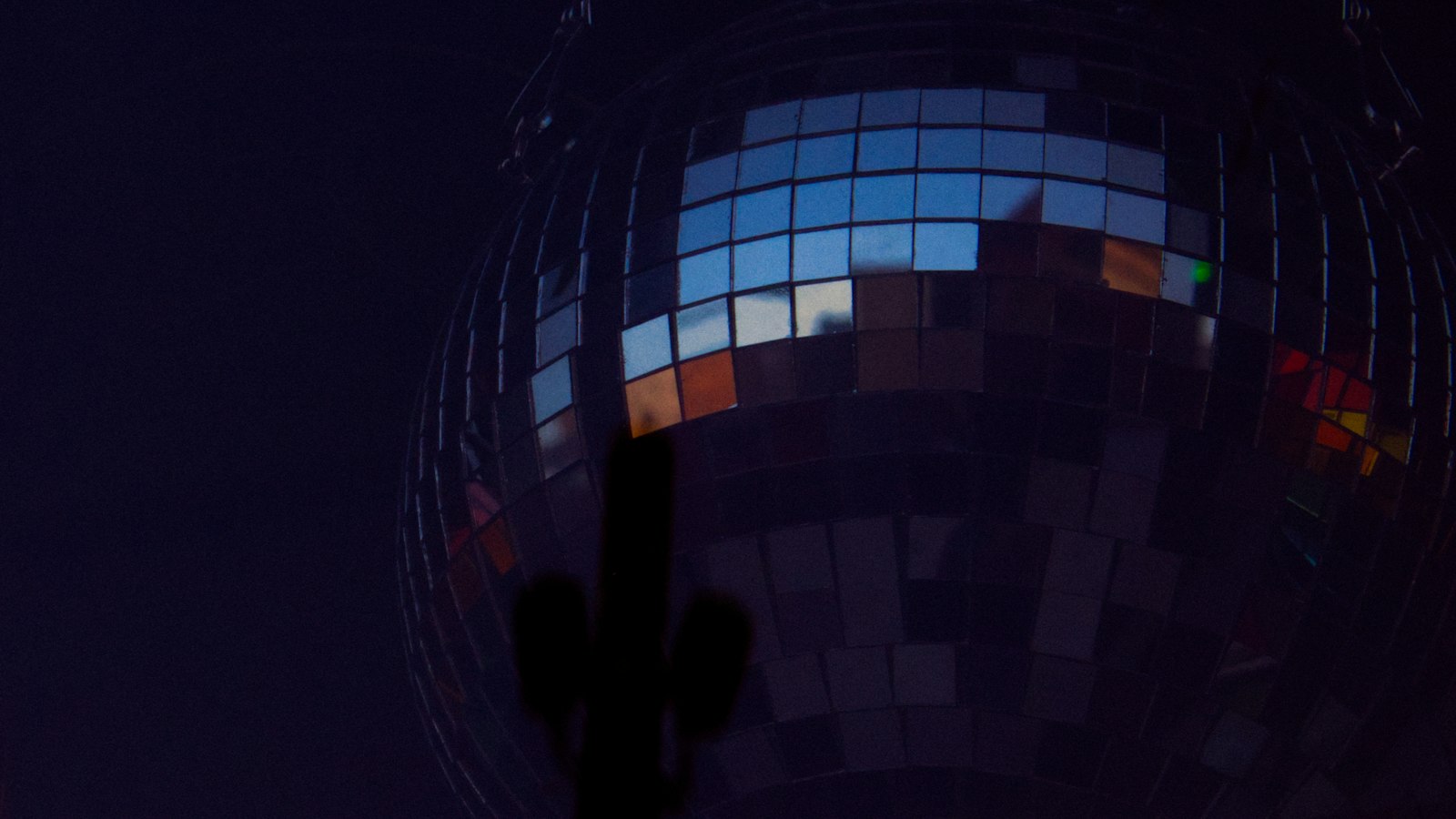 A glitterball reflecting light in a dark room