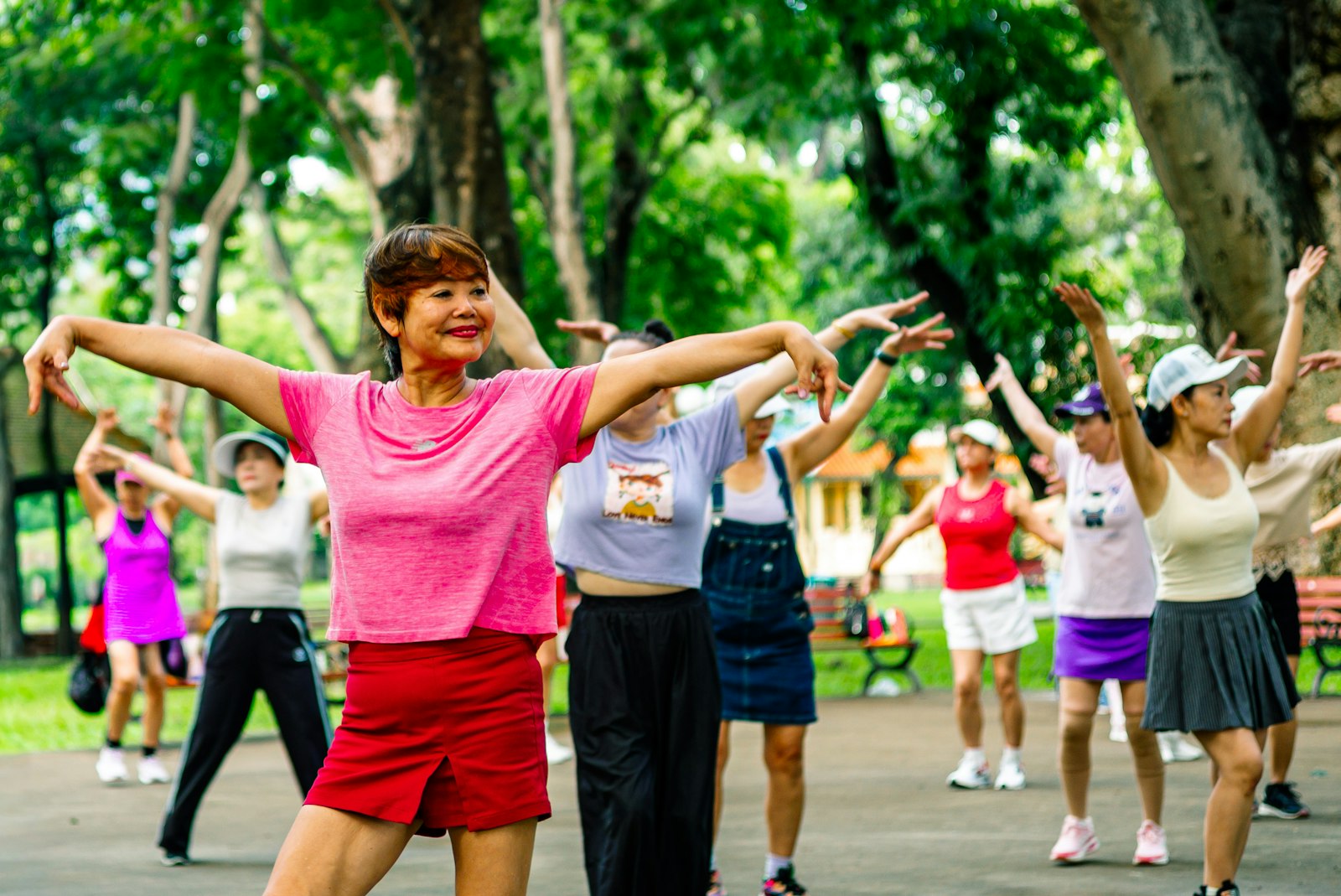 Group of older women doing an outdoor exercise class in a park