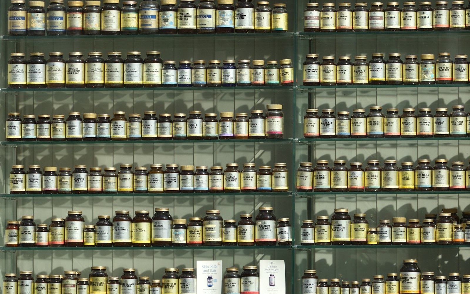 Shelves of supplement bottles in a health shop, where ashwagandha for stress is sold alongside hundreds of other products
