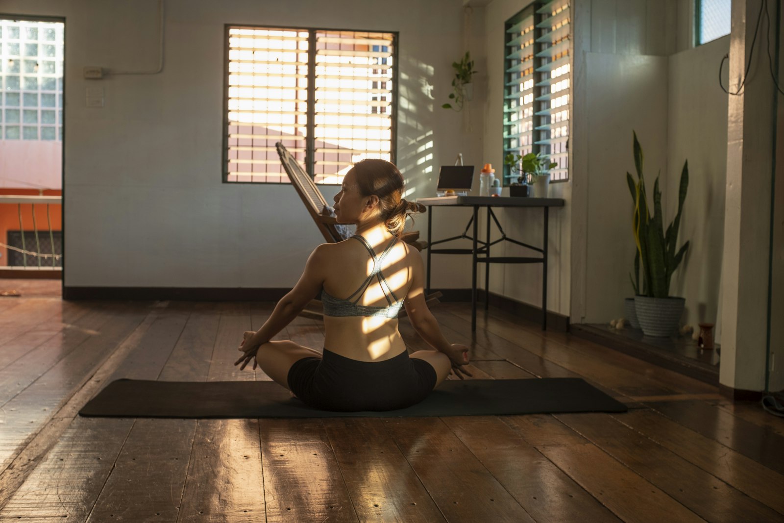 Woman meditating on a yoga mat in a sunlit room, a low-risk alternative to ashwagandha for stress