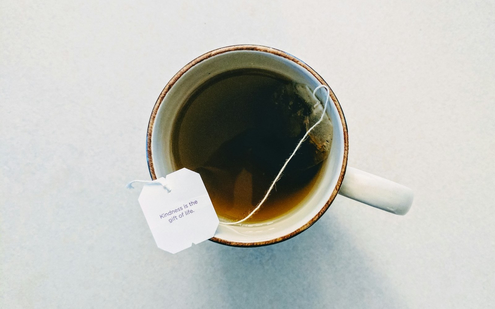 Cup of tea with a tea bag on a pale table, a simple evening alternative to ashwagandha for stress and sleep