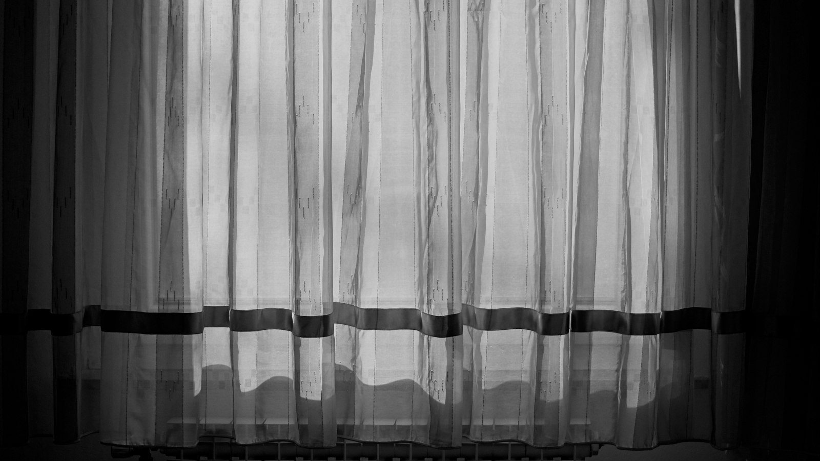 Bedroom with sheer curtains and morning light, a sensible place for a budget air purifier