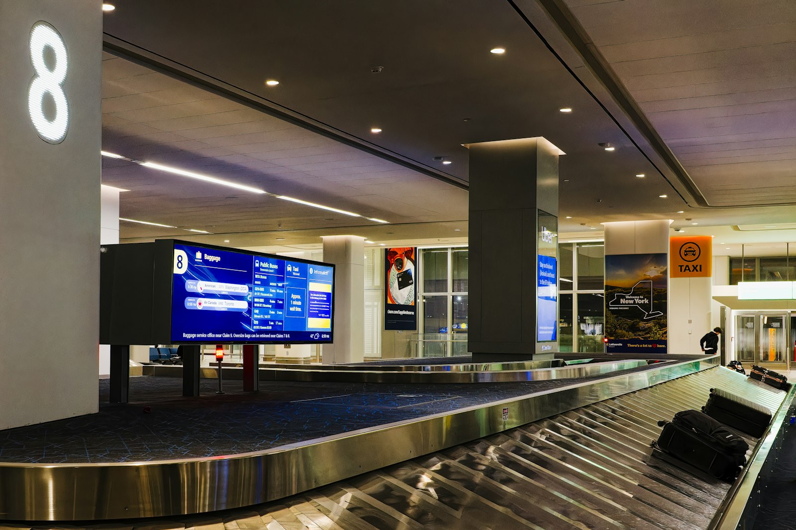 Best luggage tracker under £30: bags on a conveyor belt in an airport baggage claim hall