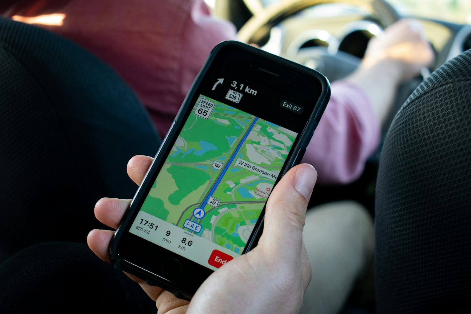 Hand holding a smartphone showing a map, the view you get from a luggage tracker app