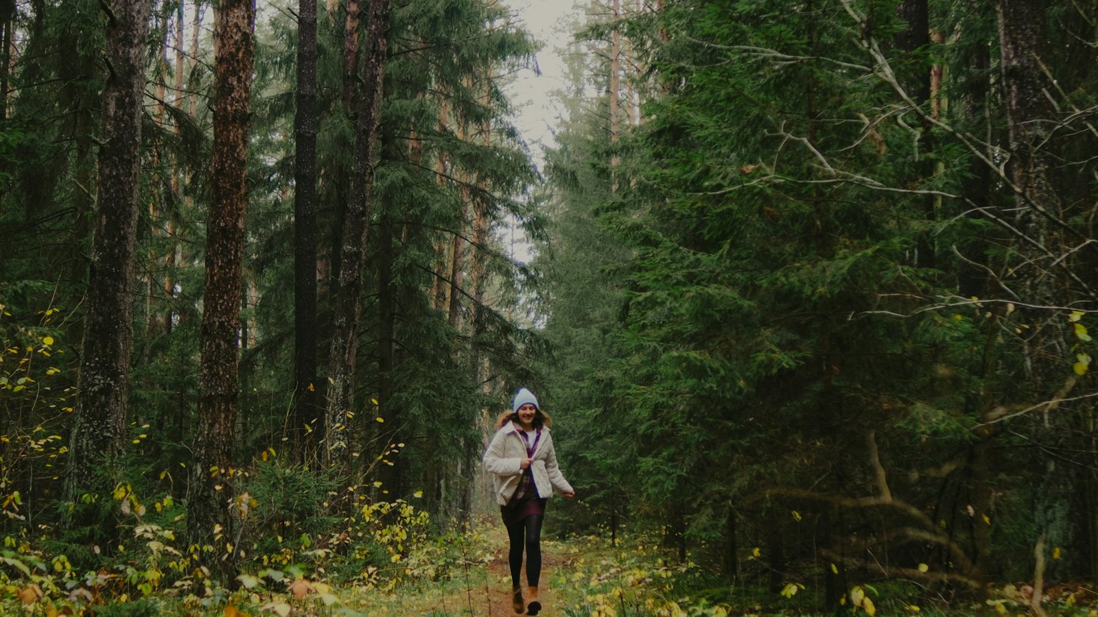 Woman walking briskly along a wooded autumn path, a natural setting for a Japanese walking workout