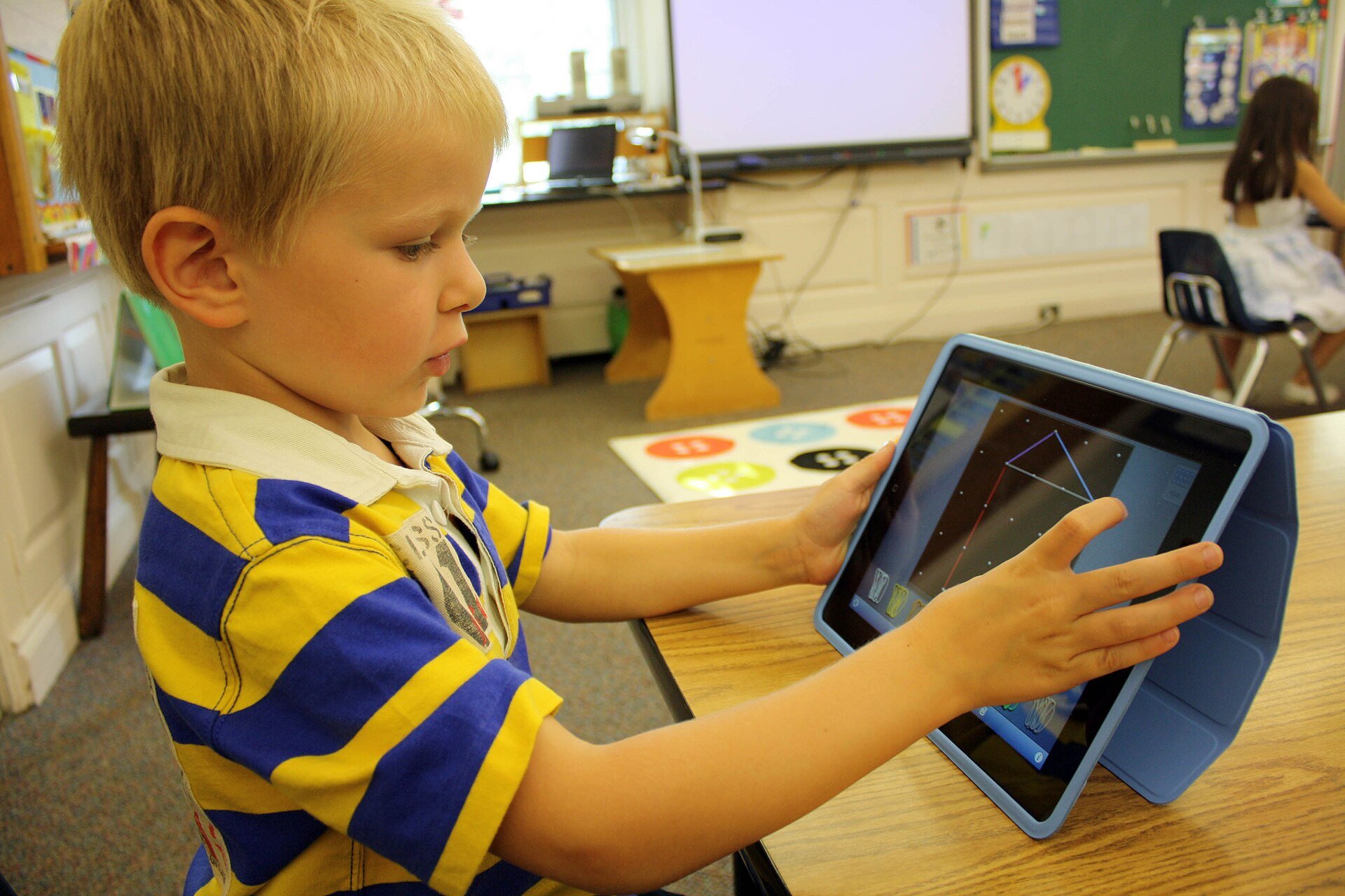 A young child using a tablet in a protective case, the kind of use the best kids tablet under £150 has to survive