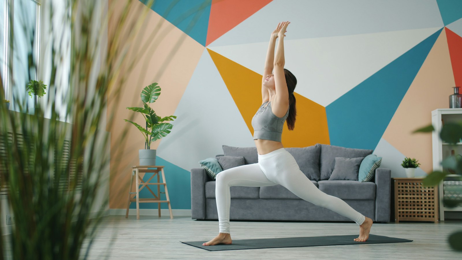 A woman doing stretching and mobility work at home, a low cost alternative to a massage gun