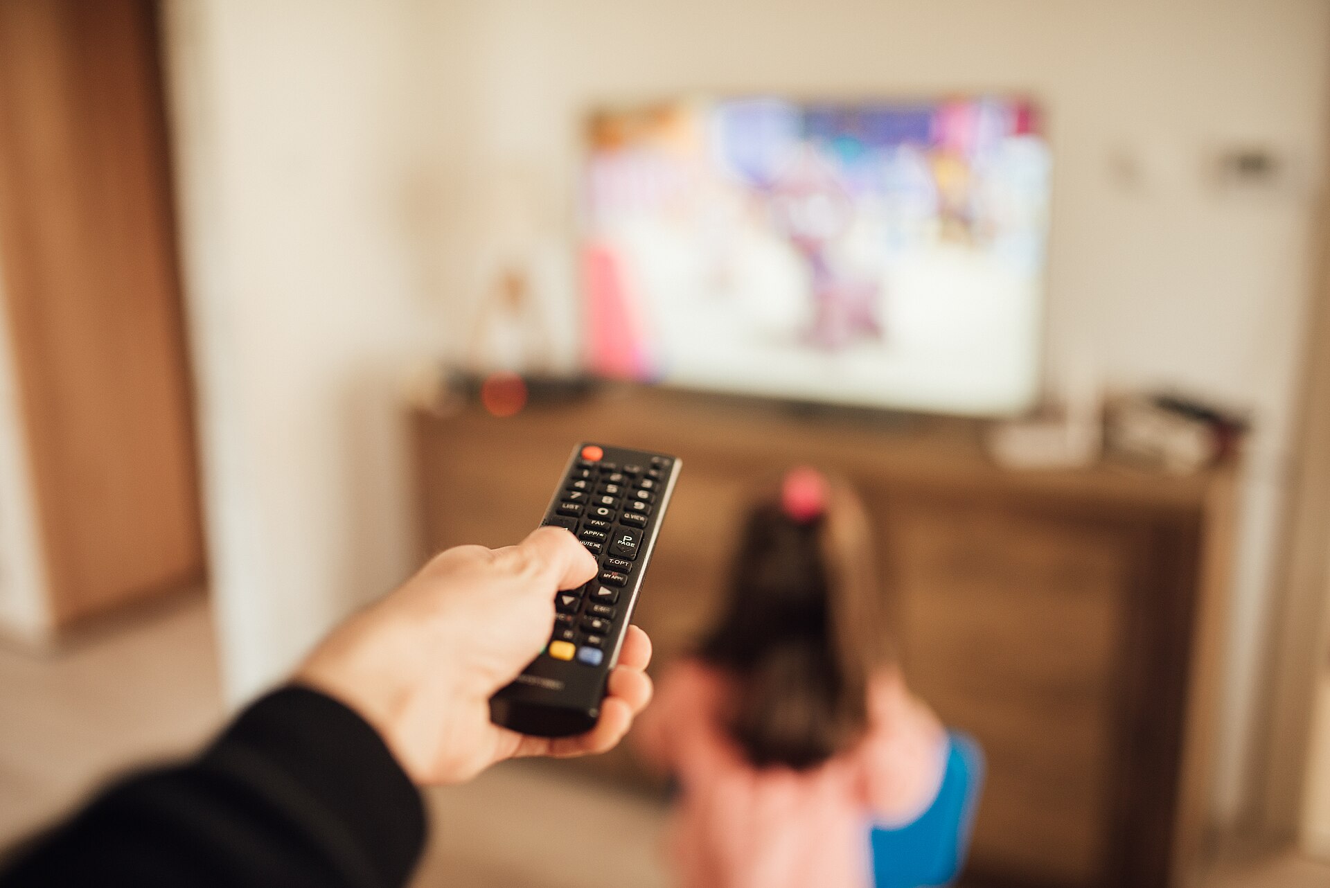 Parent with a remote control and a young girl in front of a television, the on-demand audience behind Strictly ratings