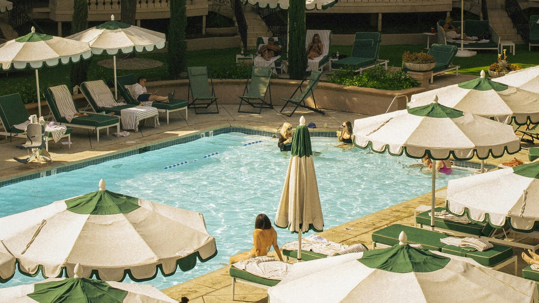 Parasols and sun loungers around a hotel pool in warm winter light