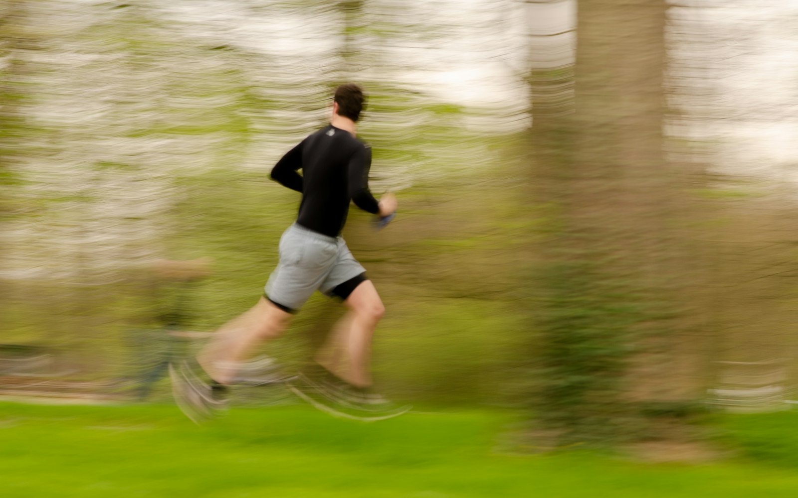 Jogger in motion through a green park, blurred, illustrating a short harder session that sits above zone 2 cardio
